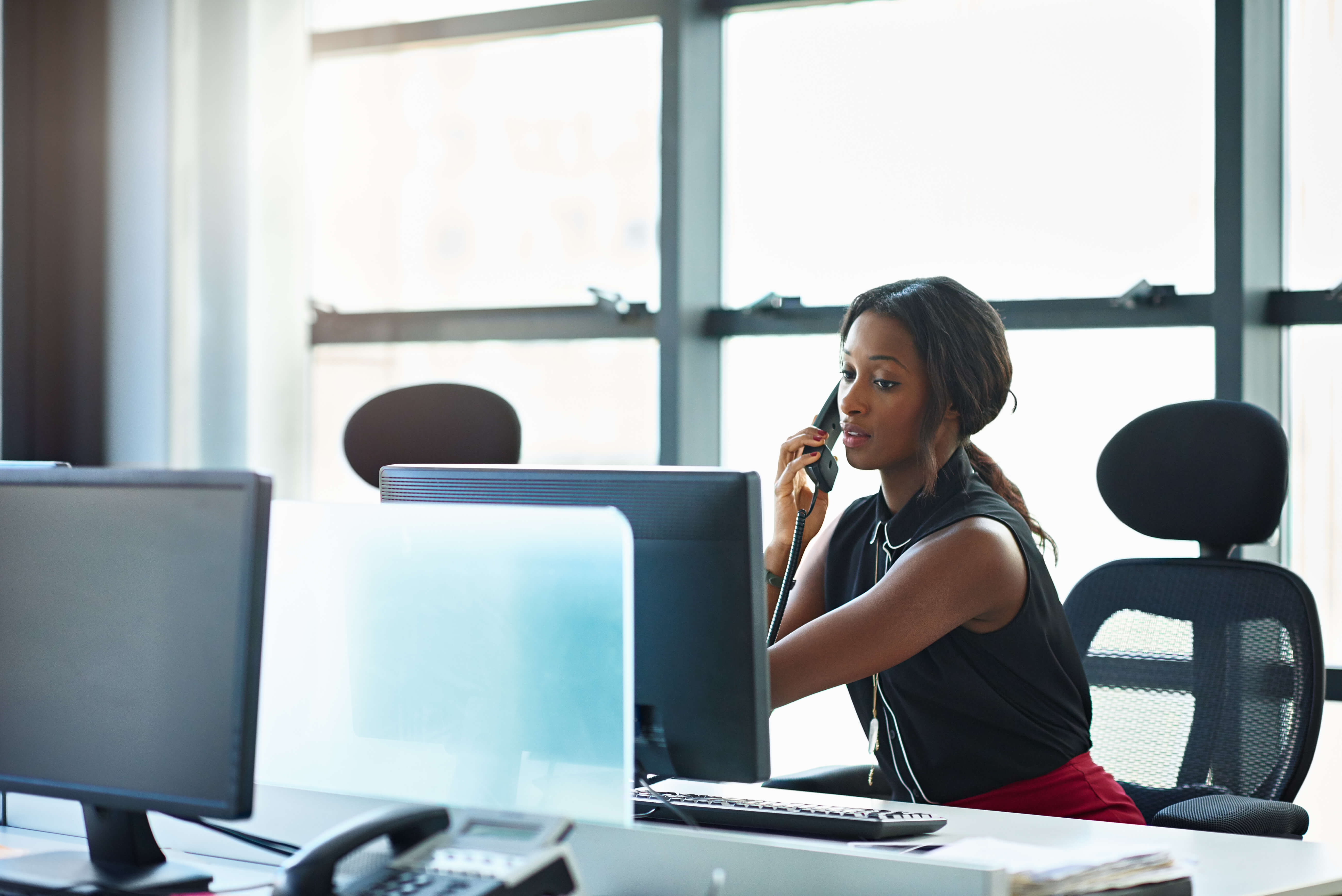 Businesswoman talking on the phone in office - Contact One Call Center